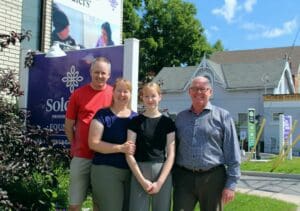 A family standing in front of a home