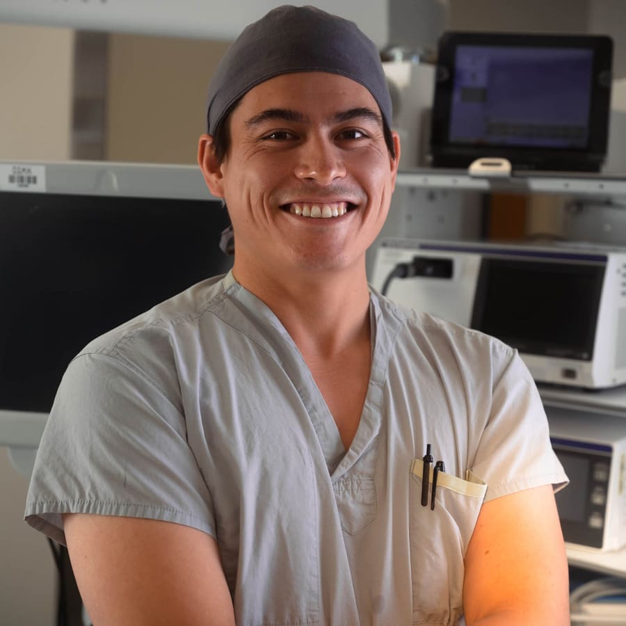 A male nurse in scrubs and a hat