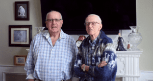 Two older men standing next to each other.