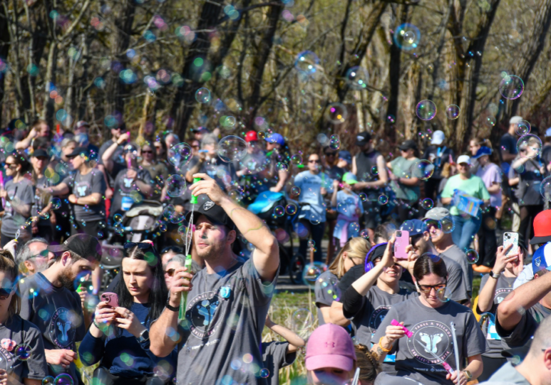 A crowd of people blowing bubbles in the air.